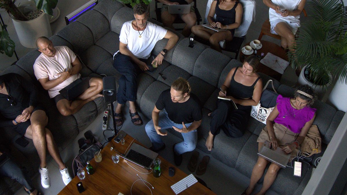 Participants of Mastermind #3 seen from above, on sofas around a low table with laptops and notebooks.